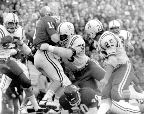 FILE - In this Nov. 25, 1971, file photo, Nebraska's Rich Glover (79) brings down Oklahoma quarterback Jack Mildren (11) as Nebraska defenders Bob Terrio (45) and Dave Mason (25) close in during a college football game in Norman, Okla., on Thanksgiving Day. The game on Thanksgiving 50 years ago is back in the spotlight as Nebraska and Oklahoma renew their rivalry on Saturday, Sept. 18, 2021. (Lincoln Journal Star via AP, File)