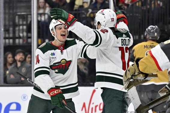Minnesota Wild center Joel Eriksson Ek (14) and left wing Matt Boldy (12) reacts after a goal by Boldy against the Vegas Golden Knights during the first period of an NHL hockey game Saturday, April 1, 2023, in Las Vegas. (AP Photo/David Becker)