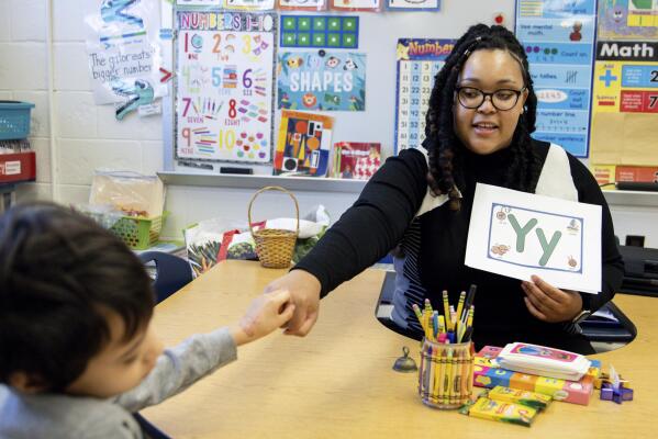 Student teacher Lana Scott, who plans to graduate from Bowie State University in the spring of 2023, teaches a small group of kindergartners at Whitehall Elementary School the alphabet, Tuesday, Jan. 24, 2023, in Bowie, Md. (AP Photo/Julia Nikhinson)