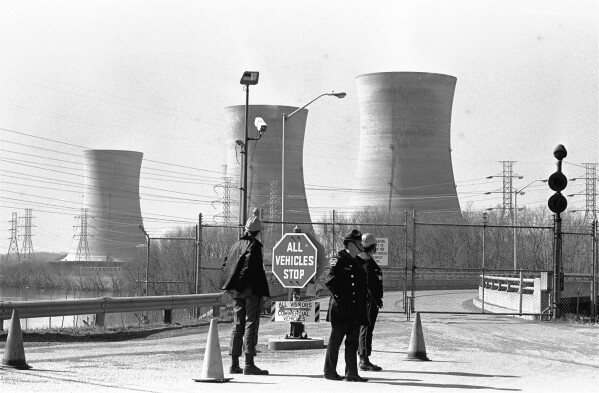 FILE - In this undated file photo, a Pennsylvania state police officer and plant security guards stand outside the closed front gate to the Metropolitan Edison nuclear power plant on Three Mile Island near Harrisburg, Pa., after the plant was shut down following a partial meltdown on March 28, 1979. Friday, March 28, 2014 marks the 35th anniversary of the partial core meltdown at the nuclear power plant.  (AP Photo/Paul Vathis, File)