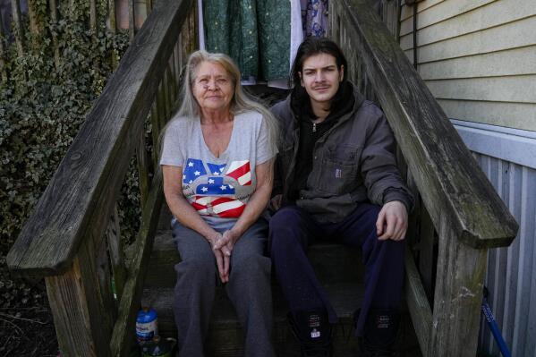 Lanette Clendaniel, left, mother of Sarah Beth Clendaniel, and her grandson Daniel Clites, 20, nephew of Sarah Beth Clendaniel, pose for a photograph for The Associated Press outside her home, Wednesday, Feb. 8, 2023, in North East, Md. U.S. Attorneys for Maryland announced the arrests and a federal criminal complaint charging Sarah Beth Clendaniel, of Catonsville, and Brandon Clint Russell, of Orlando, with conspiracy to destroy an energy facility. (AP Photo/Julio Cortez)