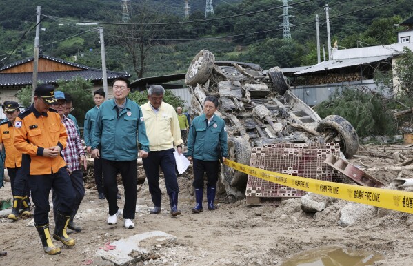 South Korean President Yoon Suk Yeol, fourth from left, looks around a flood damaged area in Yecheon, South Korea, Monday, July 17, 2023. (Jin Sung-chul/Yonhap via AP)