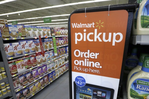 FILE - A sign encouraging customers to order grocery items online and pick them up at a store is displayed at a WalMart Neighborhood Market in Bentonville, Ark., Thursday, June 4, 2015. Walmart is the latest company to join the growing flock of major advertisers to pull spending from X, Elon Musk鈥檚 beleaguered social media company, amid concerns about hate speech 鈥� as well as reaching a sizeable audience on the platform. (AP Photo/Danny Johnston, File)