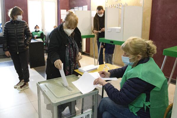 A woman wearing a face mask to help curb the spread of COVID-19 casts her ballot at a polling station during second round of national municipal elections in Tbilisi, Georgia, Saturday, Oct. 30, 2021. Most of Saturday's runoffs pit candidates from the ruling Georgian Dream party against challengers from the United National Movement that was founded by imprisoned former President Mikheil Saakashvili. (AP Photo/Shakh Aivazov)