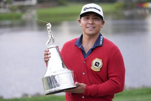 Kurt Kitayama holds the championship trophy after winning the Arnold Palmer Invitational golf tournament Sunday, March 5, 2023, in Orlando, Fla. (AP Photo/John Raoux)