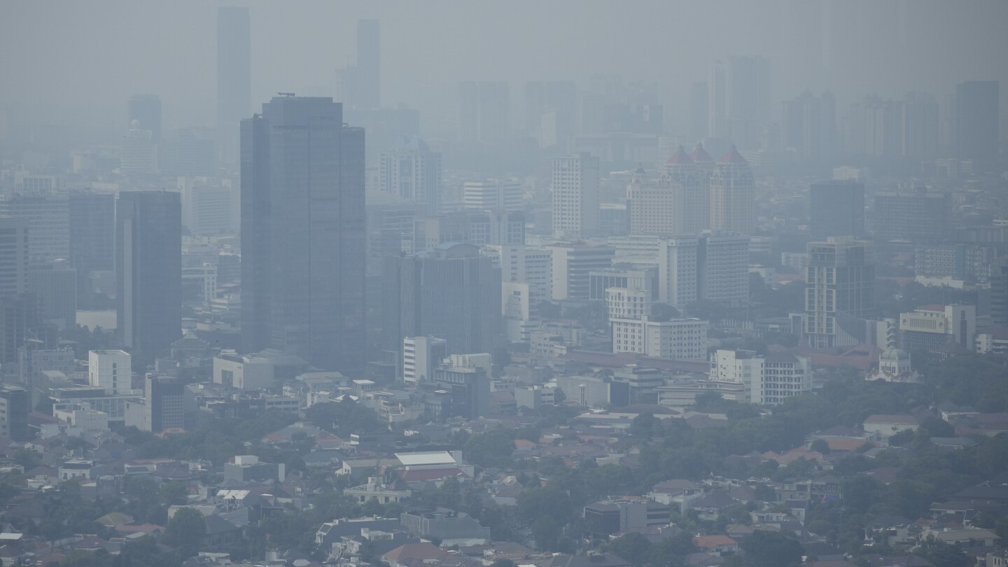FILE - Haze blankets the main business district in Jakarta, Indonesia, Aug. 11, 2023. The world’s corporations produce so much climate change pollut