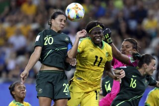 FILE - Australia's Sam Kerr, top left, jumps for the ball with Jamaica's Khadija Shaw, center, during the Women's World Cup Group C soccer match at Stade des Alpes stadium in Grenoble, France, June 18, 2019. Players from the Jamaican women’s national team took to social media on Thursday, June 15, 2023, to decry their federation’s support of the team and its preparation heading into the Women’s World Cup next month. (AP Photo/Laurent Cipriani, File)