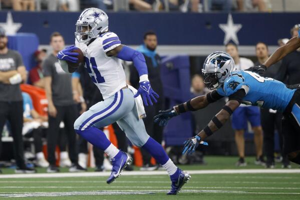 Dallas Cowboys running back Ezekiel Elliott (21) gets past Carolina Panthers safety Sam Franklin (42) for a long gain in the second half of an NFL football game in Arlington, Texas, Sunday, Oct. 3, 2021. (AP Photo/Ron Jenkins)
