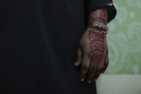 Rohingya child bride, F, age 16, stands in an apartment in Kuala Lumpur, Malaysia, on Oct. 5, 2023. F came to Malaysia from Myanmar amid escalating violence from the military in her village. She married her husband the same day they met. "I wasn't ready to be married, but I didn't have a choice," she said. (AP Photo/Victoria Milko)