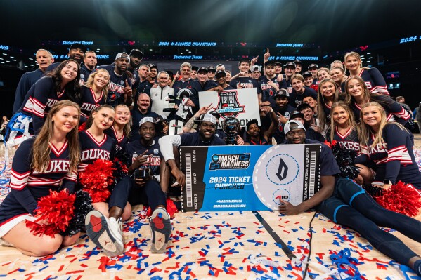 Duquesne players, cheerleaders and team staff pose after an NCAA college basketball game against Virginia Commonwealth in the championship of the Atlantic 10 Conference tournament Sunday, March 17, 2024, in New York. (AP Photo/Peter K. Afriyie)