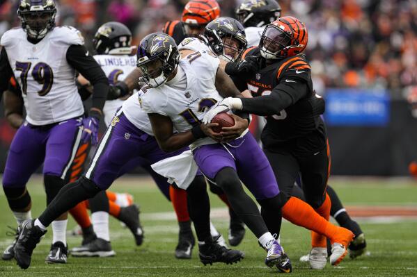 Baltimore Ravens quarterback Anthony Brown (12) is chased by Cincinnati Bengals defensive end Joseph Ossai (58) in the second half of an NFL football game in Cincinnati, Sunday, Jan. 8, 2023. (AP Photo/Jeff Dean)
