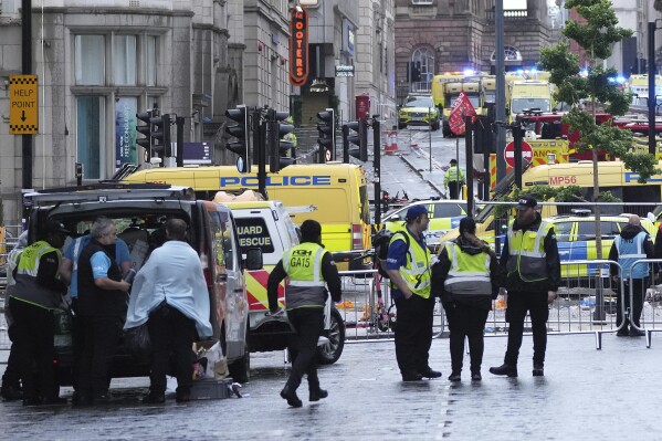 Police and emergency personnel deal with an incident near the Liver Building during the Premier League winners parade in Liverpool, England, Monday, May 26, 2025.(AP Photo/Jon Super)