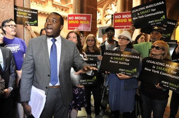 FILE — Chris Alexander, then policy coordinator for Drug Policy Alliance, who is now New York's Office of Cannabis Management's executive director, speaks as advocates urge New York state legislators to support the Marijuana Regulation and Taxation Act at the state Capitol, May 8, 2018, in Albany, N.Y. Licensed marijuana sales are expected to launch sometime next year in New York, where adult use of the drug was legalized last March. Lawmakers and the governor's office are negotiating about a $200 million fund to help people of color, women and some others start marijuana businesses. (AP Photo/Hans Pennink, File)