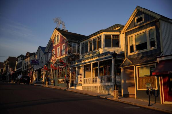 File - Early-morning light shines on shops on Main Street, Saturday, June 11, 2022, in Bar Harbor, Maine. Small businesses face a mix of old and new challenges as 2023 begins. A looming recession, still high (although easing) inflation and labor woes are a few things small businesses will have to tackle. (AP Photo/Robert F. Bukaty, File)