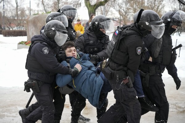 FILE - Police detain a man trying to lay flowers to honor Alexei Navalny at a monument in St. Petersburg, Russia, to victims of Soviet repression, on Saturday, Feb. 17, 2024. Over the last decade, Vladimir Putin's Russia evolved from a country that tolerates at least some dissent to one that ruthlessly suppresses it. Arrests, trials and long prison terms — once rare — are commonplace. (AP Photo, File)