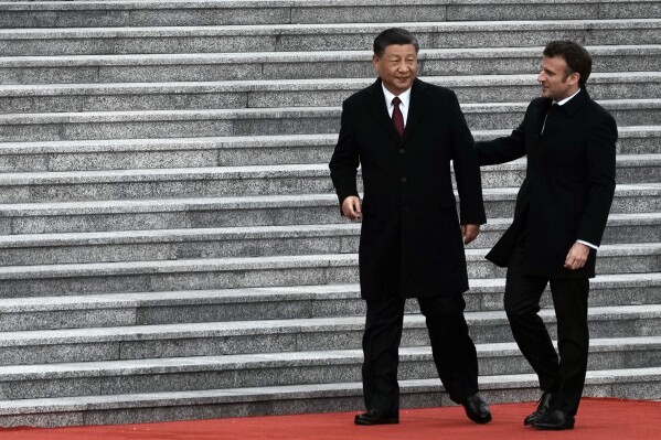 FILE - Chinese President Xi Jinping, left, and France's President Emmanuel Macron attend a welcome ceremony, at the Great Hall of the People in Beijing, China, on April 6, 2023. French President Emmanuel Macron will seek to press China's Xi Jinping to use his influence to move Russia toward ending the war in Ukraine during a two-day state visit to France. Both leaders were also expected to discuss trade disputes over electric cars, cognac and cosmetics. (AP Photo/Thibault Camus, File)