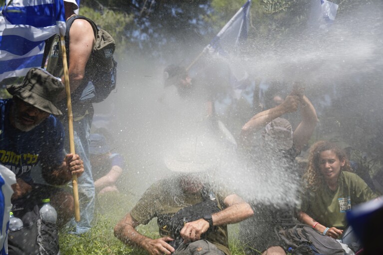Israeli police use water cannon to disperse demonstrators during a protest against plans by Prime Minister Benjamin Netanyahu's government to overhaul the judicial system, outside the Knesset, Israel's parliament, in Jerusalem, Monday, July 24, 2023. (AP Photo/Ariel Schalit)