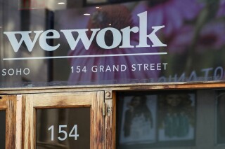 FILE - This Oct. 15, 2019 file photo shows a WeWork logo at the entrance to one of their office spaces in the SoHo neighborhood of New York. WeWork is warning there’s “substantial doubt” about its ability continue business as a going concern as a result of financial losses, projected cash needs and other factors. The New York-based workspace-sharing company said Tuesday, Aug. 8, 2023 that it's ability to stay in business depends on its ability to improve its liquidity and profitability over the next 12 months. (AP Photo/Mary Altaffer, File)