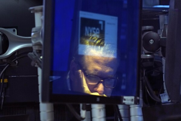 File - Specialist Gregg Maloney is reflected in a video screen on the floor of the New York Stock Exchange, on Sept. 13, 2023. (AP Photo/Richard Drew, File)