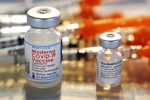 FILE - Vials for the Moderna and Pfizer COVID-19 vaccines are seen at a temporary clinic in Exeter, N.H. on Thursday, Feb. 25, 2021. A falsehood online suggests COVID-19 vaccines are linked to male infertility. Experts say there is no evidence for that claim. (AP Photo/Charles Krupa, File)