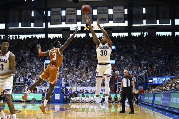 Kansas guard Ochai Agbaji (30) goes up to shoot over Texas guard Courtney Ramey (3) during the first half of an NCAA college basketball game in Lawrence, Kan., Saturday, March 5, 2022. (AP Photo/Reed Hoffmann)