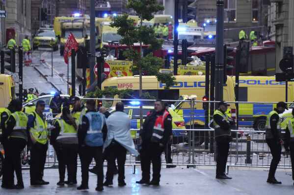 Police and emergency personnel deal with an incident near the Liver Building during the Premier League winners parade in Liverpool, England, Monday, May 26, 2025.(AP Photo/Jon Super)