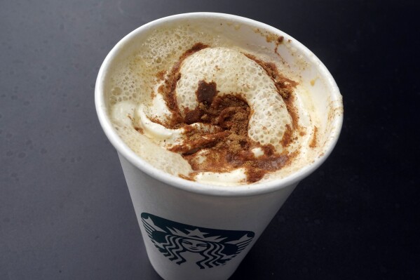 A Pumpkin Spice Latte drink rests on a table at a Starbucks in New York, Thursday, Aug. 24, 2023. The seasonal drink that made pumpkin spice a star is marking two decades in the world. (AP Photo/Richard Drew)
