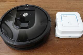 FILE - In this Thursday, Aug. 25, 2016, photo, an iRobot Roomba vacuum, left, and Braava Jet floor cleaner are displayed at the company's headquarters in Bedford, Mass.  The Federal Trade Commission is investigating Amazon’s $1.7 billion acquisition of iRobot. In a regulatory filing Tuesday, Sept. 20, 2022, iRobot said both it and Amazon received a request for additional information in connection with an FTC review of the merger.   (AP Photo/Charles Krupa, File)