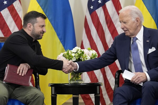 U.S. President Joe Biden shakes hands with Ukrainian President Volodymyr Zelenskyy in Paris, Friday, June 7, 2024. (AP Photo/Evan Vucci)