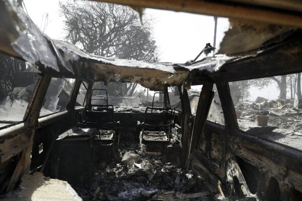 
              A wildfire-ravaged property is seen through the inside of a burned vehicle Monday, Nov. 12, 2018, in Malibu, Calif. Los Angeles County Fire Chief Daryl Osby says he expects further damage assessments to show that hundreds more homes have been lost on top of the 370 already counted as lost in Southern California's huge wildfires. (AP Photo/Marcio Jose Sanchez)
            