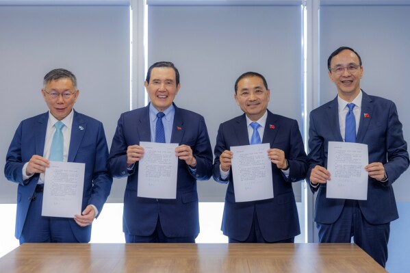 In this photo taken Nov. 15, 2023 and released by KMT, from left Taiwan People's Party chairman, TPP chairman and presidential nominee Ko Wen-je, former president Ma Ying-jeou, KMT presidential nominee Hou Yu-ih and KMT Chairman Eric Chu hold up a join statement for photos in Taipei. Taiwan's two main opposition parties, both of which have vowed to restart talks with China, announced a joint presidential ticket for January's election in a deal that could bring a major political upset for the Asian democracy. (KMT via AP)