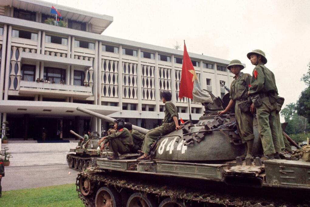 Victorious North Vietnamese troops on tanks take up positions outside Independence Palace in Saigon, April 30, 1975, the day the South Vietnamese government surrendered, ending the Vietnam War. Communist flags fly from the palace and the tank. (AP Photo/Yves Billy)