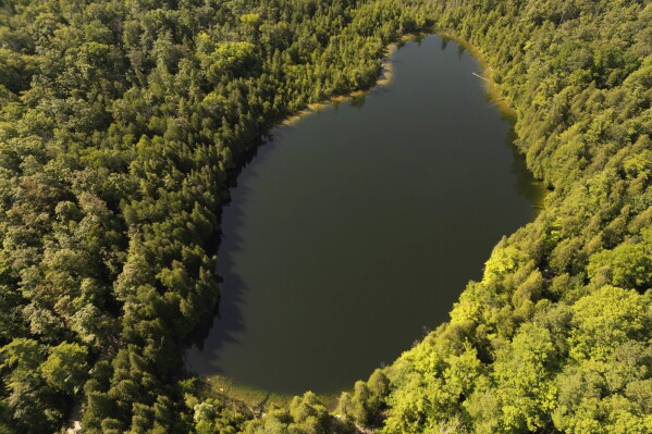 Trees surround Crawford Lake in Milton, Ontario., on Monday, July 10, 2023. A team of scientists is recommending the start of a new geological epoch defined by how humans have impacted the Earth should be marked at the pristine Crawford Lake outside Toronto in Canada. (Cole Burston/The Canadian Press via AP)