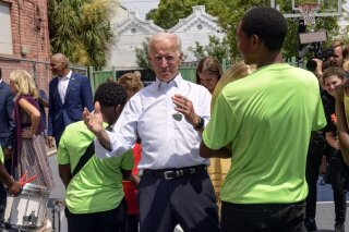 Democratic presidential candidate former Vice President Joe Biden speaks to kids as he tours the Youth Empowerment Project that targets at risk youth and young people with the drum line in New Orleans, Tuesday, July 23, 2019. (AP Photo/Matthew Hinton)