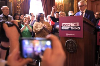 Supporters of Wisconsin Gov. Tony Evers' plan to re-draw the state's legislative maps react as he stands at a podium during the bill-signing event at the Wisconsin State Capitol in Madison, Wis. Monday, Feb. 19, 2024. Democrats tried unsuccessfully for more than a decade to overturn the Republican-drawn maps. But it wasn’t until control of the state Supreme Court flipped in August after the election of liberal Justice Janet Protasiewicz that Democrats found a winning formula. (John Hart/Wisconsin State Journal via AP)