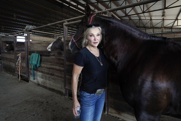Ranch owner Gilda Jackson poses for a photo as she works with one of her horses in the arena on her property in Paradise, Texas, Monday, Aug. 21, 2022. (AP Photo/Tony Gutierrez)