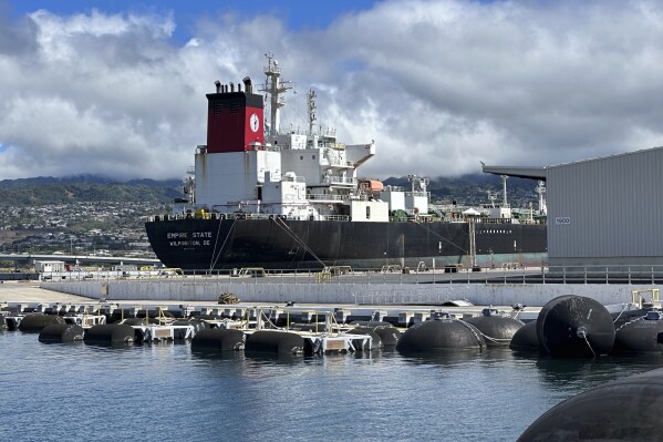 The tanker Empire State sits at a pier at Joint-Base Pearl Harbor-Hickam, Hawaii on Friday, Oct. 13, 2023 before the U.S. military next week begins draining fuel from the Red Hill Bulk Fuel Storage Facility. The fuel will flow downhill through pipelines for 3 miles (4.8 kilometers) to tanker ships. The Red Hill facility is being drained and closed after it leaked fuel into a drinking water well and poisoned 6,000 people two years ago. (AP Photo/Audrey McAvoy)