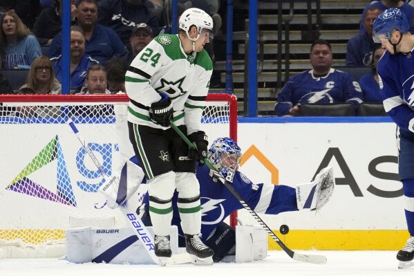 Dallas Stars center Roope Hintz (24) tries to deflect the puck past Tampa Bay Lightning goaltender Andrei Vasilevskiy (88) during the second period of an NHL hockey game Monday, Dec. 4, 2023, in Tampa, Fla. (APPhoto/Chris O'Meara)