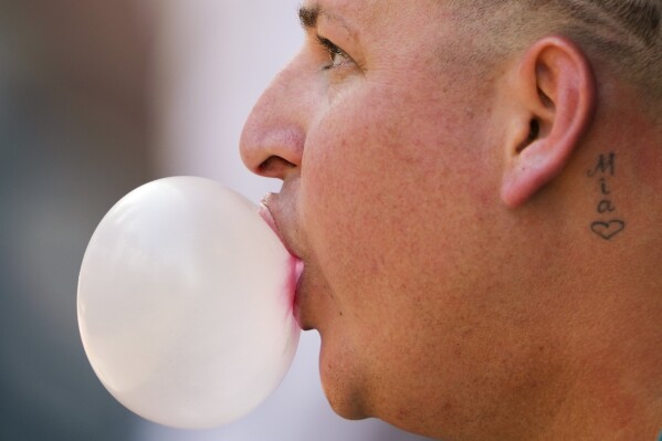 File - Seattle Mariners starting pitcher Jhonathan Díaz blows a bubble during the first inning of a spring training baseball game against the Cleveland Guardians, Feb. 25, 2024, in Peoria, Ariz. Gum maker Mars says its research shows half of gum consumers chew to relieve stress or help their focus. (AP Photo/Lindsey Wasson, File)