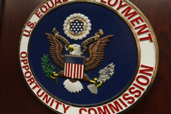 FILE - The emblem of the U.S. Equal Employment Opportunity Commission is shown on a podium in Vail, Colo., Tuesday, Feb. 16, 2016, in Denver. A federal judge on Monday, June 17, 2024, granted the U.S. Conference of Catholic Bishops, as well as employers in two Southern states, temporary relief from complying with a federal rule that would have required them to provide workers with time off and other workplace accommodations for abortions. The lawsuits challenge the Equal Employment Opportunity Commission's regulations stating that 2022 Pregnant Workers Fairness Act covers abortion. (AP Photo/David Zalubowski, File)