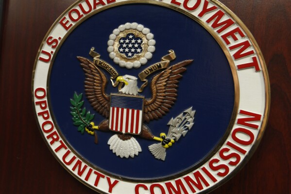  FILE - The emblem of the U.S. Equal Employment Opportunity Commission is shown on a podium in Vail, Colo., Tuesday, Feb. 16, 2016, in Denver. A federal judge on Monday, June 17, 2024, granted the U.S. Conference of Catholic Bishops, as well as employers in two Southern states,  temporary relief from complying with a federal rule that would have required them to provide workers with time off and other workplace accommodations for abortions. The lawsuits challenge the Equal Employment Opportunity Commission's regulations stating that 2022 Pregnant Workers Fairness Act covers abortion. (AP Photo/David Zalubowski, File)