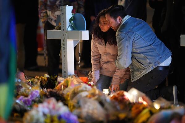 People embrace during a candlelight vigil on a corner near the site of a weekend mass shooting at a gay bar, late Monday, Nov. 21, 2022, in Colorado Springs, Colo. (AP Photo/Jack Dempsey)