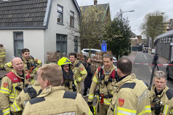Firefighters gather in Eden, Netherlands, Saturday, March 30, 2024. Heavily armed police have cordoned off part of a Dutch town and say that multiple people are being held hostage in a building there. It is unclear how many people are being held. Police said in a message on X, formerly Twitter, that “at the moment there is no indication of a terrorist motive.” (AP Photo/Aleksandar Furtula)