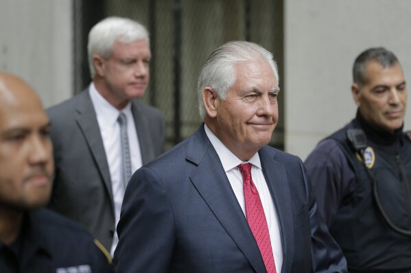 Former Exxon CEO and ex-Secretary of State Rex Tillerson, second from right, leaves a courthouse in New York, Wednesday, Oct. 30, 2019. As Exxon faced the prospect of new climate regulations, the energy giant's leaders sought a full understanding of how they would affect the bottom line, Tillerson told a court Wednesday in a securities fraud lawsuit brought by the New York attorney general's office. (AP Photo/Seth Wenig)