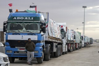 FILE - Trucks carrying humanitarian aid line up at the Rafah Border Crossing, Egypt, on the way to Gaza, Sunday, Nov. 19, 2023. A cumbersome process of Israeli inspections and other hurdles is slowing the entry of aid into Gaza, two U.S. senators say after a visit to Egypt's Rafah crossing into to besieged territory. Hundreds of trucks are lined up at Rafah, sometimes waiting weeks to go through the process. (AP Photo/Amr Nabil, File)