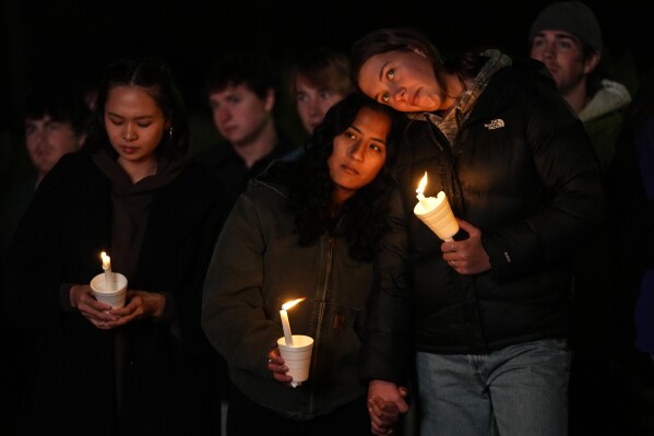 People gather at a vigil for the victims of Wednesday's mass shootings, Sunday, Oct. 29, 2023, outside the Basilica of Saints Peter and Paul in Lewiston, Maine. (AP Photo/Matt Rourke)