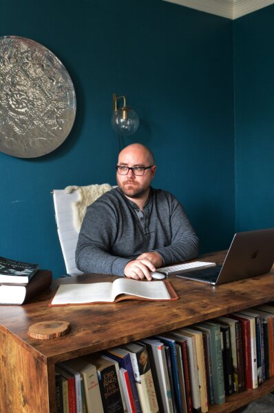 In this photo provided by Brett Seidl, Jonathon Seidl sits in his home office in Dallas on Wednesday, March 18, 2020. He said he wasn't worried about the coronavirus despite his anxiety disorder. But that changed. The 33-year-old digital media strategist, who takes medication, said his concern was less about getting sick than about the battering the economy could sustain. Would he be able to feed his family? Would there be a run on food stores? He could not shake his worries. (Brett Seidl via AP)