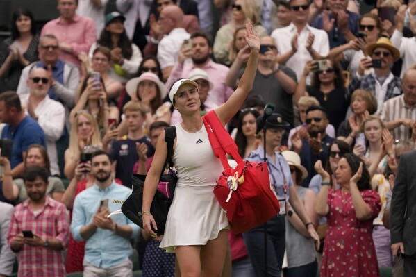Ukraine's Elina Svitolina waves to the crowd as she leaves court after losing to Czech Republic's Marketa Vondrousova in a women's singles semifinal match on day eleven of the Wimbledon tennis championships in London, Thursday, July 13, 2023. (AP Photo/Alberto Pezzali)