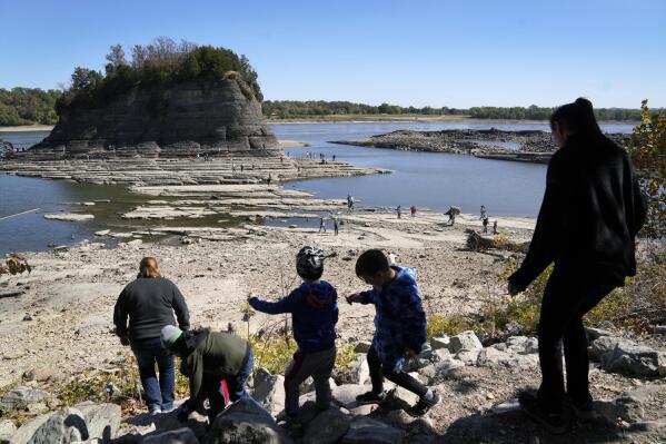 FILE - People walk toward Tower Rock to check out the attraction normally surrounded by the Mississippi River and only accessible by boat, Oct. 19, 2022, in Perry County, Mo. Foot traffic to the rock formation has been made possible because of near record low water levels along the river. (AP Photo/Jeff Roberson, File)