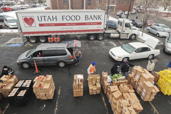 FILE - Utah Food Bank volunteers load groceries for the needy at a mobile food pantry distribution site Wednesday, Dec. 21, 2022, in Salt Lake City. Supporting nonprofits on GivingTuesday this year could have a bigger impact than usual as nonprofits and industry groups say donations so far are down compared with previous years. Many organizations will be looking to make up the difference on GivingTuesday, which is the Tuesday after Thanksgiving, Nov. 28, 2023. (AP Photo/Rick Bowmer)